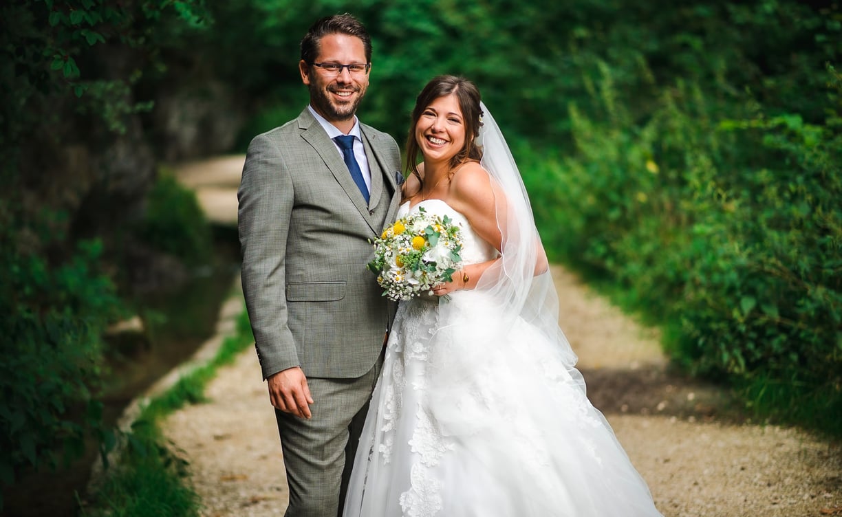 Brautpaar lächelnd auf einem Waldweg in der Verenaschlucht – Hochzeit von Misch & Simu