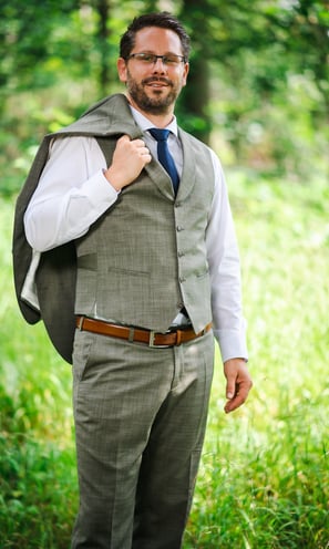 Bräutigam mit Jacke über der Schulter im Wald – Hochzeit von Misch & Simu