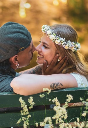 Brautpaar küsst sich auf einer Parkbank – Hochzeit von Tina & Will