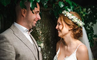 Brautpaar schaut sich unter Efeu in die Augen – Hochzeit von Romana & Remo