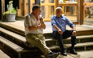 Zwei Gäste im Gespräch auf einer Holztreppe am Abend – Hochzeit von Rege & Sven