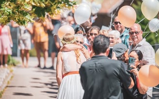Braut umarmt einen Gast, umgeben von Ballonen – Hochzeit von Tina & Will