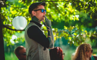 Gast mit Sonnenbrille und Mütze im Garten – Hochzeit von Rege & Sven