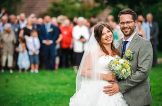 Brautpaar umarmt sich vor den Hochzeitsgästen – Hochzeit von Misch & Simu