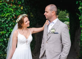 Brautpaar vor einer grünen Hecke im Schlossgarten – Hochzeit von Romana & Remo
