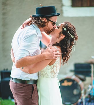 Brautpaar küsst sich im Garten vor der Band – Hochzeit von Rege & Sven