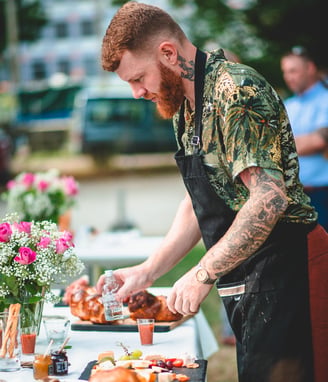 Grillmeister richtet das Buffet im Freien an – Hochzeit von Rege & Sven