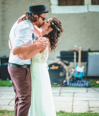 Brautpaar küsst sich im Garten vor der Band – Hochzeit von Rege & Sven