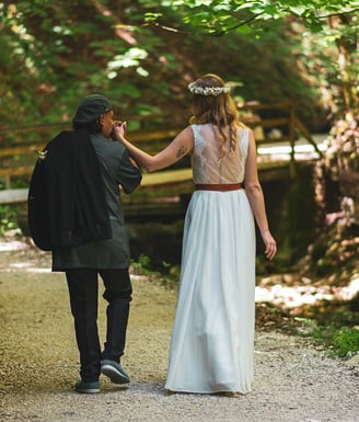 Brautpaar spaziert Hand in Hand auf einem Waldweg – Hochzeit von Tina & Will