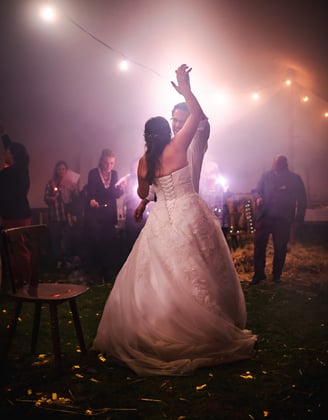Brautpaar tanzt im Nebel unter Lichterketten – Hochzeit von Misch & Simu
