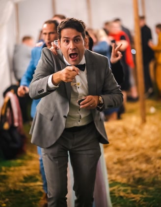 Gast im Anzug feiert ausgelassen im Festzelt – Hochzeit von Misch & Simu