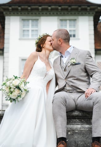 Brautpaar küsst sich vor Schloss Waldegg – Hochzeit von Romana & Remo