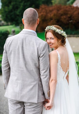 Braut blickt über die Schulter, Hand in Hand mit dem Bräutigam – Hochzeit von Romana & Remo