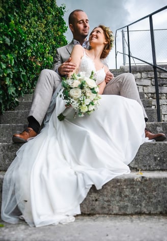 Brautpaar sitzt auf der Treppe von Schloss Waldegg – Hochzeit von Romana & Remo