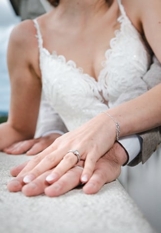 Hände des Brautpaars mit Eheringen – Hochzeit von Romana & Remo