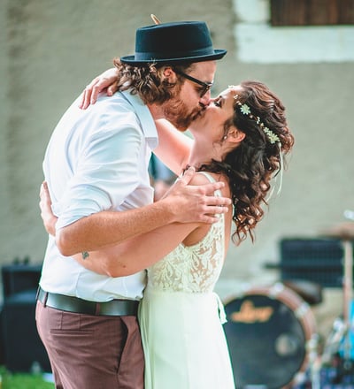 Brautpaar küsst sich im Garten vor der Band – Hochzeit von Rege & Sven