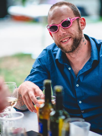 Gast mit pinker Sonnenbrille am Tisch – Hochzeit von Rege & Sven