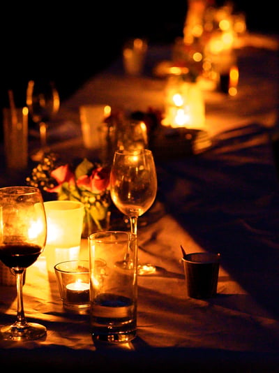 Kerzenlicht und Weingläser auf dem Tisch bei Nacht – Hochzeit von Rege & Sven