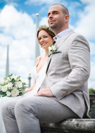 Brautpaar vor blauem Himmel im Schlossgarten – Hochzeit von Romana & Remo