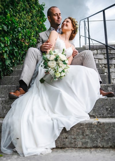 Brautpaar sitzt auf der Treppe von Schloss Waldegg – Hochzeit von Romana & Remo