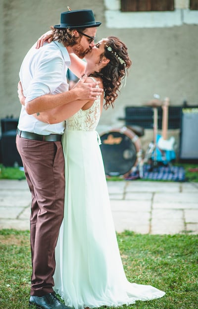 Brautpaar küsst sich im Garten vor der Band – Hochzeit von Rege & Sven