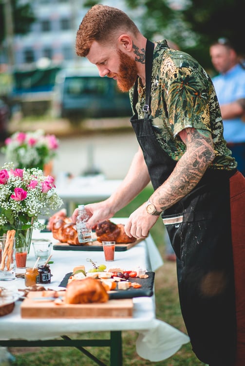Grillmeister richtet das Buffet im Freien an – Hochzeit von Rege & Sven