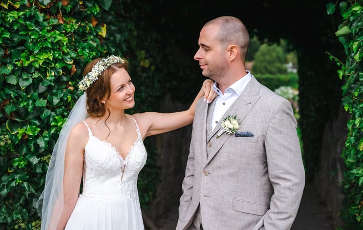 Brautpaar vor einer grünen Hecke im Schlossgarten – Hochzeit von Romana & Remo