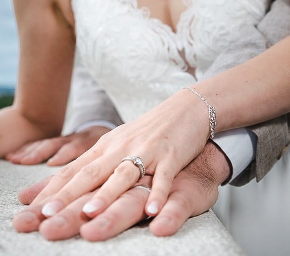 Hände des Brautpaars mit Eheringen – Hochzeit von Romana & Remo