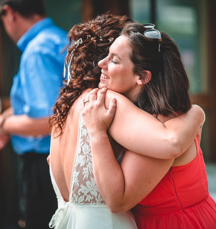Braut umarmt eine Freundin herzlich – Hochzeit von Rege & Sven